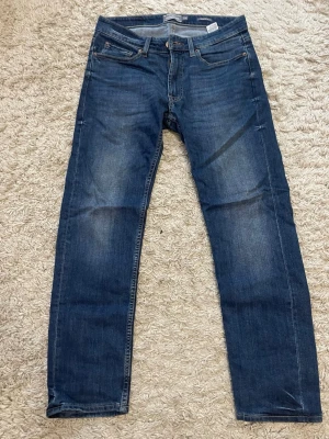Blå regular fit jeans från Dressmann - Säljer ett par klassiska blå jeans från Dressmann i regular fit storlek 31-30. Har använts få gånger, väldigt rena och nya, inga fel. Väldigt sköna och perfekta i storleken. PRIS KAN ALLTID DISKUTERAS 