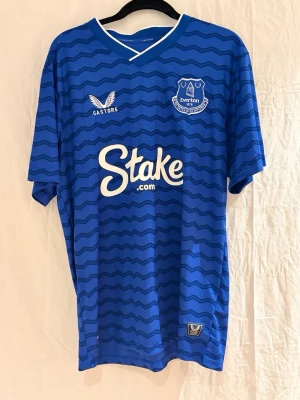 Everton tröja Keane #5  - Säljer en blå Everton matchtröja med Keane och nummer 5 på ryggen. Tröjan har ett vågigt mönster i mörkblått, vit logga samt klubbmärket på bröstet. Perfekt för dig som älskar Everton och vill ha en snygg och billig tröja i bra kvalite. Bara att höra av sig vid frågor. 