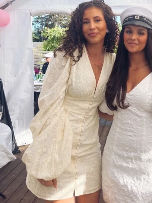 Gul ADOORE klänning ”Florence” med puffärmar - ‼️INTRESSEKOLL!!! På SLUTSÅLD Superfin gul kort klänning från Adoore med djup v-ringning, puffiga långärmar och knappar framtill. Klänningen har ett subtilt blommönster i tyget och markerad midja. Perfekt för student eller sommarens tillfällen.