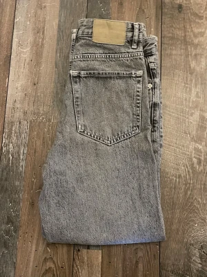 Gråa jeans från Pull&Bear - Säljer ett par gråa jeans från Pull&Bear med raka ben. Jeansen har klassisk femficksdesign och är gjorda i ett slitstarkt bomullsmaterial. Perfekta för en avslappnad och trendig look.