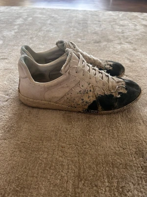Maison margiela gats - Feta Maison margiela gats med splatter i storlek 43. Skicket är sådär. Bara skorna tillkommer. Skorna har fått lite blå färg från mina jeans men går att ta bort