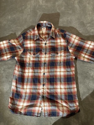 Rutig skjorta Levi’s  - En rutig skjorta från Levi’s i färgerna mörkblå, vinröd, vitt och guld. Mycket bra skick, riktig skön. Storlek XS men passar S lika bra.