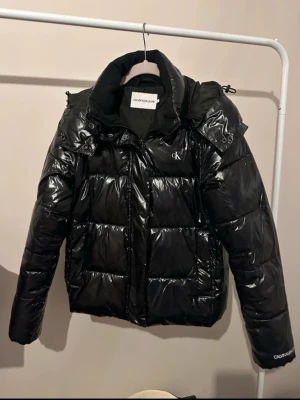 Svart pufferjacka från Calvin Klein - Calvin Klein high shine puffer jacket. Den är si storlek M men tycker mer den sitter som S.  Är i nyskick, modellen finns inte längre, köpte den för 2 599 kr. Priset går att diskutera 