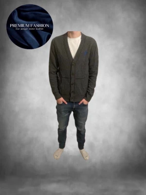 Abercrombie & Fitch cardigan/kofta - Tja säljer en tvär fet mörkgrå kofta från Abercrombie & Fitch med knäppning framtill och två fickor. Klassisk v-ringad design och diskret blå logga på bröstet. Perfekt att slänga över en t-shirt för en avslappnad men stilren look perfekt till dagens mode och perfekt till dig som vill ha en as feta kofta!!! Storlek M killen på bilden är 183cm lång och passar bra🤩 skick 10/10 som ny🙌🏼några frågor eller funderingar är de bara att höra av sig🤗mvh PREMIUM FASHION😁