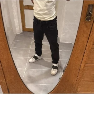 Svarta slim fit jeans herr - Säljer ett par svarta slim fit jeans med klassisk femficksdesign och normal midja. Jeansen har smal passform och raka ben, perfekta för en clean och stilren look. Materialet är stretchigt för extra komfort.