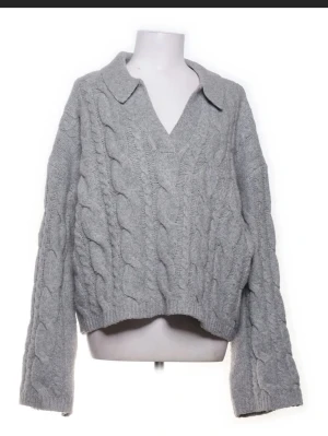 Grå kabelstickad tröja med krage - säljer denna tröjan från BikBok i storlek M, har ej används men köptes för ett års sedan.💕skriv för bilder hur den ser ut på