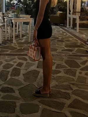 Guess Silvana mini handväska orange - Säljer en Guess Silvana 2 Compartment Mini handväska i orange och beige med mönstrat tyg och logotypdetaljer. Väskan har både handtag och en bred axelrem i orange skinnimitation. Snygg design med GG-mönster och metallogo framtill. Använd endast 1 gång nypris 1295:-