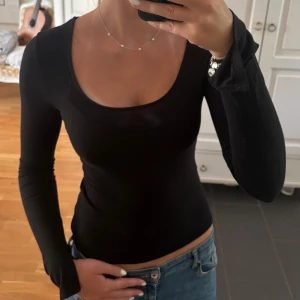 Svart långärmad topp med slits vid ärmen Gina Tricot S - En svart långärmad topp från Gina Tricot med rund, djup ringning och slits i ärmen. Modellen är tight och sitter snyggt mot kroppen. Tillverkad i mjukt och stretchigt material som känns skönt mot huden. Perfekt att styla med jeans eller kjol.