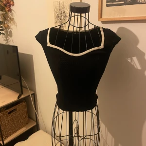 Svart ribbad topp från Gina Tricot - Svart ribbad topp från Gina Tricot med vit kant runt den fyrkantiga urringningen. Väldigt fin till jeans❤️ säljer för jag har tröttnat. Inga defekter. Storlek s