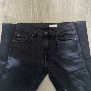 Svarta jeans från Tiger of Sweden - Snygga svarta jeans från Tiger of Sweden med klassisk femficksdesign och diskret logga på bakfickan. Jeansen har rak passform, perfekta till en stilren look. Materialet är mjukt och följsamt jeans i bomull.