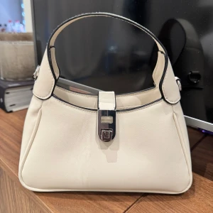 Vit väska  - Snygg väska som tyvärr aldrig använts så säljer den nu, den är kräm vit och inte så stor❣️Finns inte kvar på hemsidan tror jag☺️