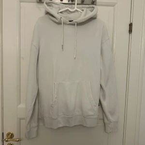 Vit hoodie från Jack & Jones - En stilren vit hoodie från Jack & Jones med klassisk känguruficka och dragsko i huvan. Tröjan har långa ärmar och ribbade muddar. Perfekt för en chill och avslappnad look. Materialet är mjuk bomull som känns skönt mot huden. Använd fåtal gånger och finns inga fläckar eller liknande, hittar inte någon storlek men skulle tippa mellan M och L 💖