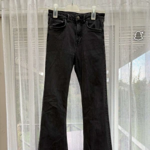 Svarta flare jeans från H&M, stl 38 - Snygga svarta flare jeans från H&M i storlek 38. Jeansen har klassisk femficksdesign, hög midja och utsvängda ben. Tillverkade i mjuk denim som sitter skönt och ger en cool siluett. Perfekta till sneakers eller boots. Jag har storlek S och passar mig jätte bra 