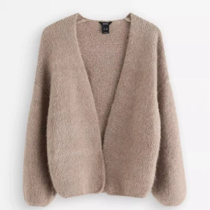 Beige stickad kofta från Linock - Mysig beige stickad kofta från Lindex med oversized passform och lång ärm. Koftan är öppen framtill och har en fluffig, mjuk känsla som gör den perfekt att slänga på sig över en t-shirt. Enkel och stilren design som passar till allt. Köpt för 399kr men inga defekter och använd 2 gånger ❤️