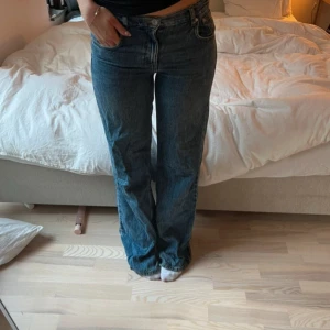 Blå raka jeans med normal passform - Säljer ett par klassiska blå jeans med rak passform och normal midja. Jeansen har fem fickor, dragkedja och knapp framtill. Perfekta till en avslappnad stil och funkar året runt.