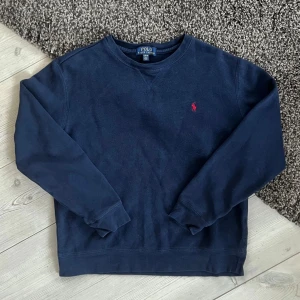 Ralph Lauren Tröja - Hej! Jag säljer denna marinblå tröja från Ralph Lauren. Den är i storlek 14-16y, så den sitter som XS. Väldigt bra skick.