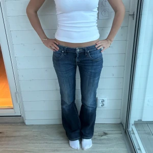 Blå bootcut jeans låg midja - Lågmidjade mörkblå bootcutjeans i storlek XS-S. Midja: 38x2 cm, innerben: 76 cm