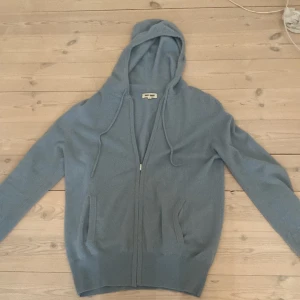 Ljusblå hoodie i kashmir från Soft Goat - Mysig ljusblå hoodie från Soft Goat i lyxig kashmir. Tröjan är väldigt skön att ha på sig! 