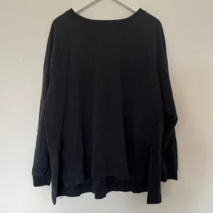 Svart långärmad tröja från Cubus - En svart långärmad tröja som är lite längre baktill från Cubus i storlek XS/S. Tröjan har en rundad hals med ribbad kant.