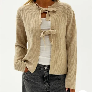 Kofta rosetter - Beige stickad kofta med söta knytningar från Nelly. Aldrig använd men lappen är borttagen. Väldigt liten i strl sitter som S/M inte L. Slutsåld på hemsidan. Nypris 400