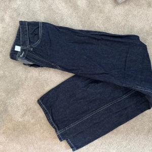 Mörkblå wide jeans mid waist - Snygga mörkblå jeans med breda ben och kontrastsömmar. Klassisk femficksmodell i jeansmaterial, perfekt för dig som gillar en avslappnad och trendig look.