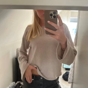 Beige stickad tröja med vida ärmar - Snygg beige stickad tröja från H&M med vida långärmar och rak passform. Tröjan har en enkel design med rund hals och är perfekt för dig som gillar en chill och stilren look. Passar till både jeans och kjol.