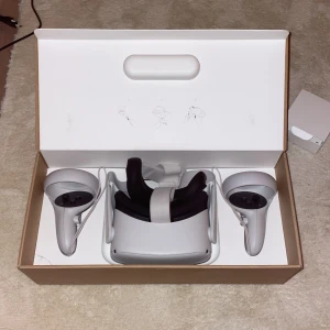 Meta Quest 2 128GB - Meta Quest 2 VR-headset med 128GB lagring, komplett med två handkontroller och originalförpackning. Produkten ser ut att vara i mycket gott skick utan synligt slitage eller defekter. Perfekt för uppslukande VR-upplevelser och spel.