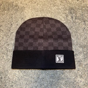 Svart rutig mössa - Säljer denna rutiga mössan i svart färg. Den kommer med tags och den örngott oanvänd.