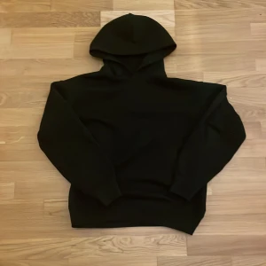 Svart baggy uniqlo hoodie - En stilren svart hoodie med huva och långa ärmar. 