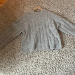 Grå stickad tröja med ribbad struktur - Jag säljer min gråa stickade tröja från Gina Tricot! Den är sparsamt använd och har inga defekter! Perfekt nu till hösten!💗😊