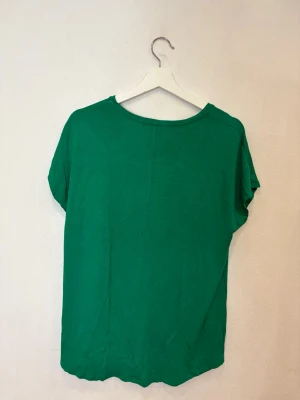 Grön t-shirt från New Yorker - Enkel och snygg grön t-shirt från New Yorker med rund halsringning och korta ärmar. Modellen är rak och lite loose fit, perfekt för en chill och avslappnad stil. Tillverkad i mjuk bomull som känns skön mot huden.