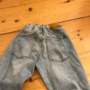 Ljusblå raka jeans LAB 158 - Snygga ljusblå jeans från LAB i rak modell med klassiska fem fickor och elastisk midja. Jeansen har en avslappnad passform och är tillverkade i mjukt denimtyg med slitningar för en cool look. Perfekta för dig som gillar enkel och stilren streetstil.