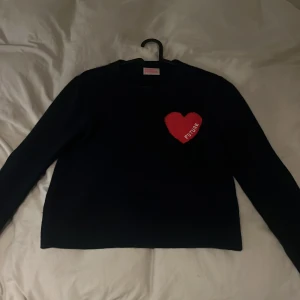 Mörkblå stickad tröja From Future XS - Supersnygg mörkblå stickad tröja från From Future i storlek XS. På bröstet finns ett rött hjärta med texten 'FUTURE' broderat. Tröjan har rund hals och långa ärmar, perfekt för dig som gillar coola detaljer och vill sticka ut. Pris kan diskuteras 