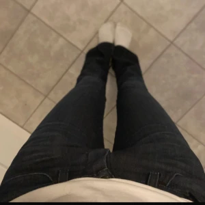 Mörkblå jeans bootcut wrangler - Säljer ett par mörkblå  jeans med klassisk femficksdesign och bootcut-ben. Jeansen har en snygg, mörk tvätt och är tillverkade i jeansmaterial med en liten stretch för extra komfort. Perfekta för dig som gillar en tidlös och stilren look.