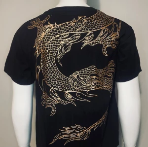 T-shirt - Cool svart t-shirt med stort gyllene draktryck fram och bak. Tillverkad i 100% mjuk bomull – bekväm och andas bra. I fint skick