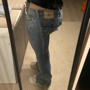 True Religion Becca Bootcut Jeans - Säljer ett par ljusblå True Religion Becca low rise bootcut jeans med snygga detaljerade bakfickor💓💓Jeansen är i strl S.