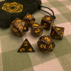 Dice set - Dice set från CritStones. Produktnamn: Golden Breach Metal RPG Dice Set. Tärningarna är tyngre då de är gjorda i metall. Grön dice bag medföljer :)