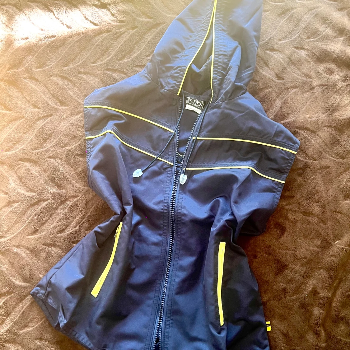 Blå vindjacka med gula detaljer