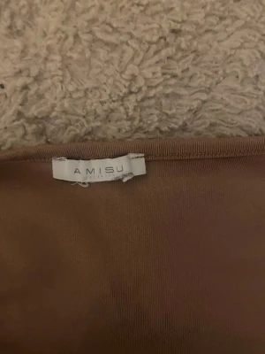 Rosa topp med fyrkantig ringning Amisu - Säljer en rosa topp från Amisu med korta ärmar och snygg fyrkantig ringning. Toppens material känns mjukt och stretchigt, perfekt för en trendig look. Enkel att matcha med både jeans och kjol.