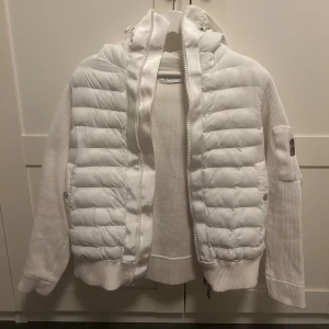Moncler pufferjacka  - Säljer nu min snygg vita pufferjacka från Moncler med stickade ärmar i färgen vit. Säljer den då den inte kommer till andvänding mer. Den är perfekt för dig som vill ha ett plagg som är lätt att matcha. Tveka inte på att höra av dig om du vill ha mer bilder eller har nån fråga!