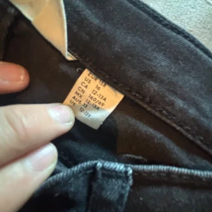 Svarta jeansbyxor i storlek 158 - Svarta jeansbyxor i klassisk rak modell med fem fickor. Byxorna har normal passform och är tillverkade i ett mjukt jeanstyg som passar perfekt till en avslappnad stil. Snygga att matcha med sneakers eller boots.