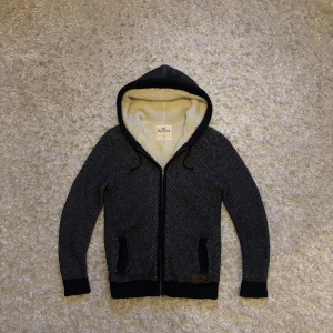 Stickad fodrad zip hoodie/kofta från Hollister - Riktigt snygg o unik mörkblå zip hoodie från Hollister. Hoodie är stickad och fodrad och därför väldigt varm. Den är använd men i mycket bra skick utan några defekter. Storlek M, tveka inte på o skriva vid fler frågor!