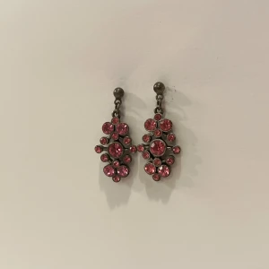 rosa örhängen - Superfina örhängen med rosa stenar. Örhängets längd är ca 3.5cm.