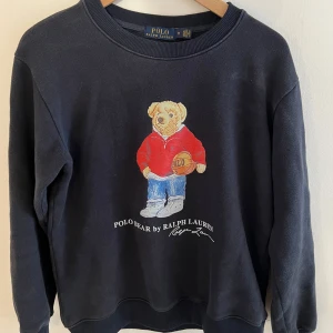 Mörkblå sweatshirt Polo Bear Ralph Lauren - Mörkblå sweatshirt från Polo Ralph Lauren med Polo Bear tryck. Tröjan är storlek M men passar även S den har hållits i bra skick