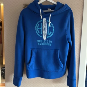 Blå hoodie från Hollister California - Hej och välkommen till BL nu säljer vi en hollister hoodie i super skick utan defekter endast lite noprig kom med frågor mvh BL