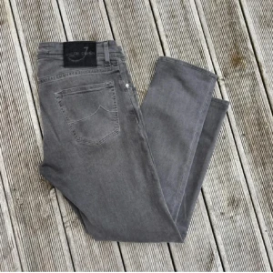 Grå jeans från Jacob Cohen - Snygga grå jeans från Jacob Cohen i bra skick enda defekten är att storleks lappen är avklippt. Midja: 43 cm. 