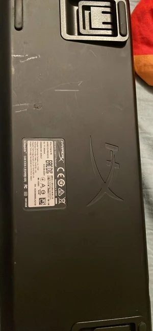 HyperX Alloy Origins Core - HyperX Alloy Origins Core mekaniskt tangentbord med röda switches för snabb respons. Kompakt TKL-design, anpassade keycaps i svart och vitt. Vissa tecken visar slitage och repor på undersidan, men tangentbordet är fullt funktionellt och perfekt för gaming.