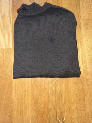 Brun stickad tröja från morris - Snygg brun stickad tröja från Morris med rund hals och diskret blå broderad logga på bröstet. Perfekt för dig som gillar stilrena och moderna kläder. Priset kan diskuteras bara att höra av sig!