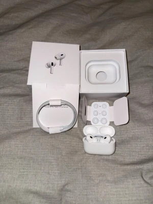 AirPods Pro - Säljer ett par AirPods Pro i mycket fint skick, komplett med originalförpackning, laddningskabel och extra öronkuddar. Trådlös laddningsetui ingår. Perfekt för brusreducering och hög ljudkvalitet. Inga synliga defekter eller slitage.