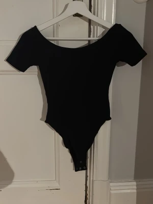 Svart body från H&M Divided XXS - Säljer en svart body från H&M Divided i storlek XXS. Den är väldigt najs material o skön till sommaren men säljer för den inte kommer till användning 🥰